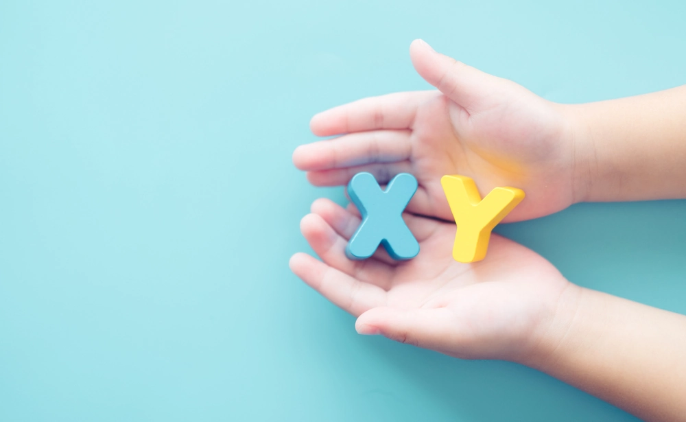 XY chromosome word on baby boy hands.kid child children gender